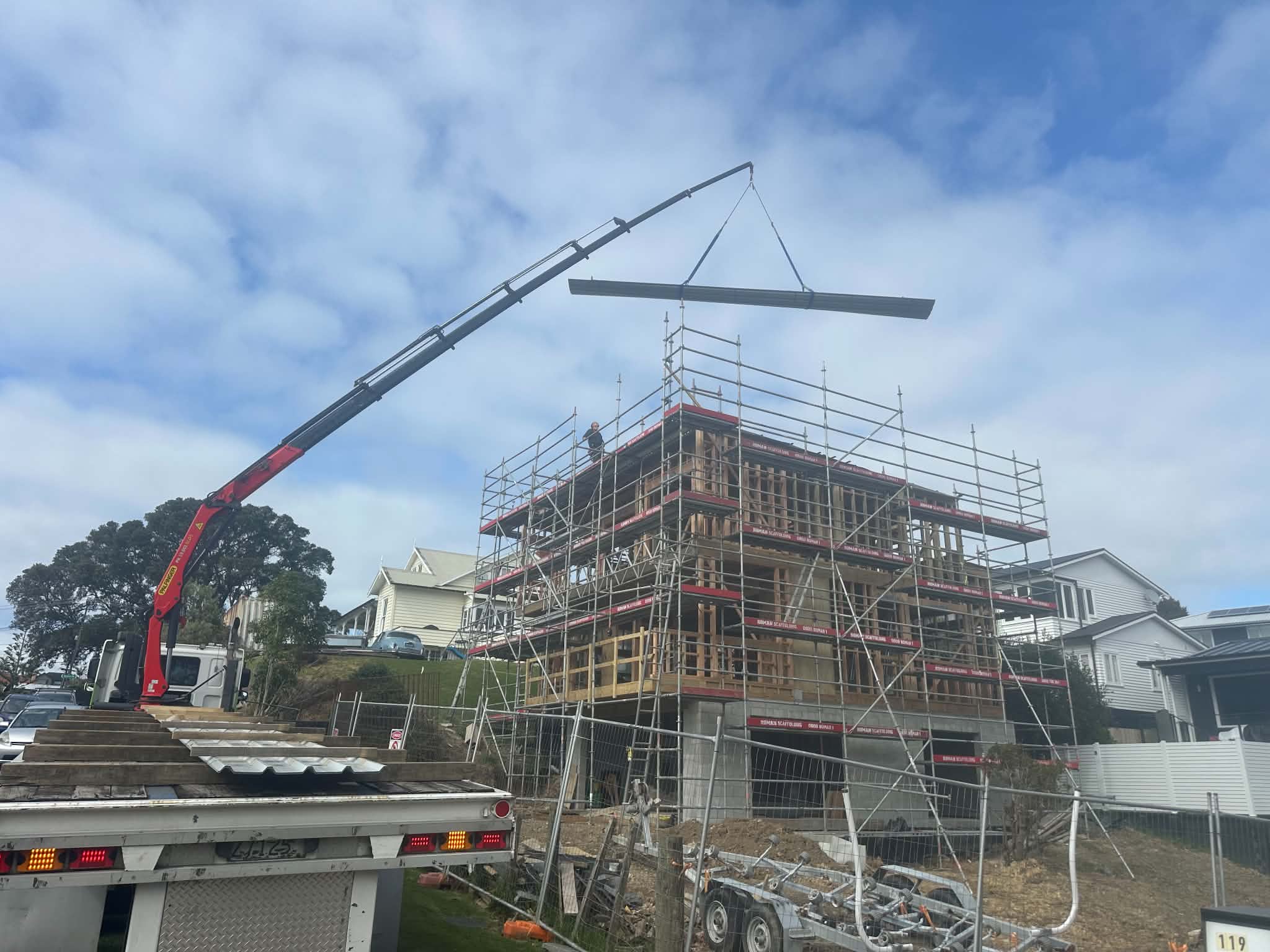 Crane lifting a steel beam onto a multi-storey build